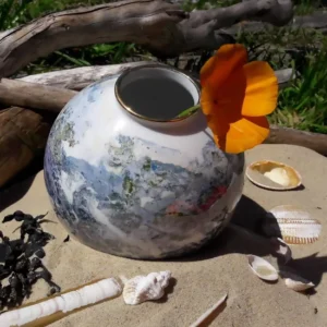 pot rond décoration abstraite exposée sur le sable entourée de coquillages